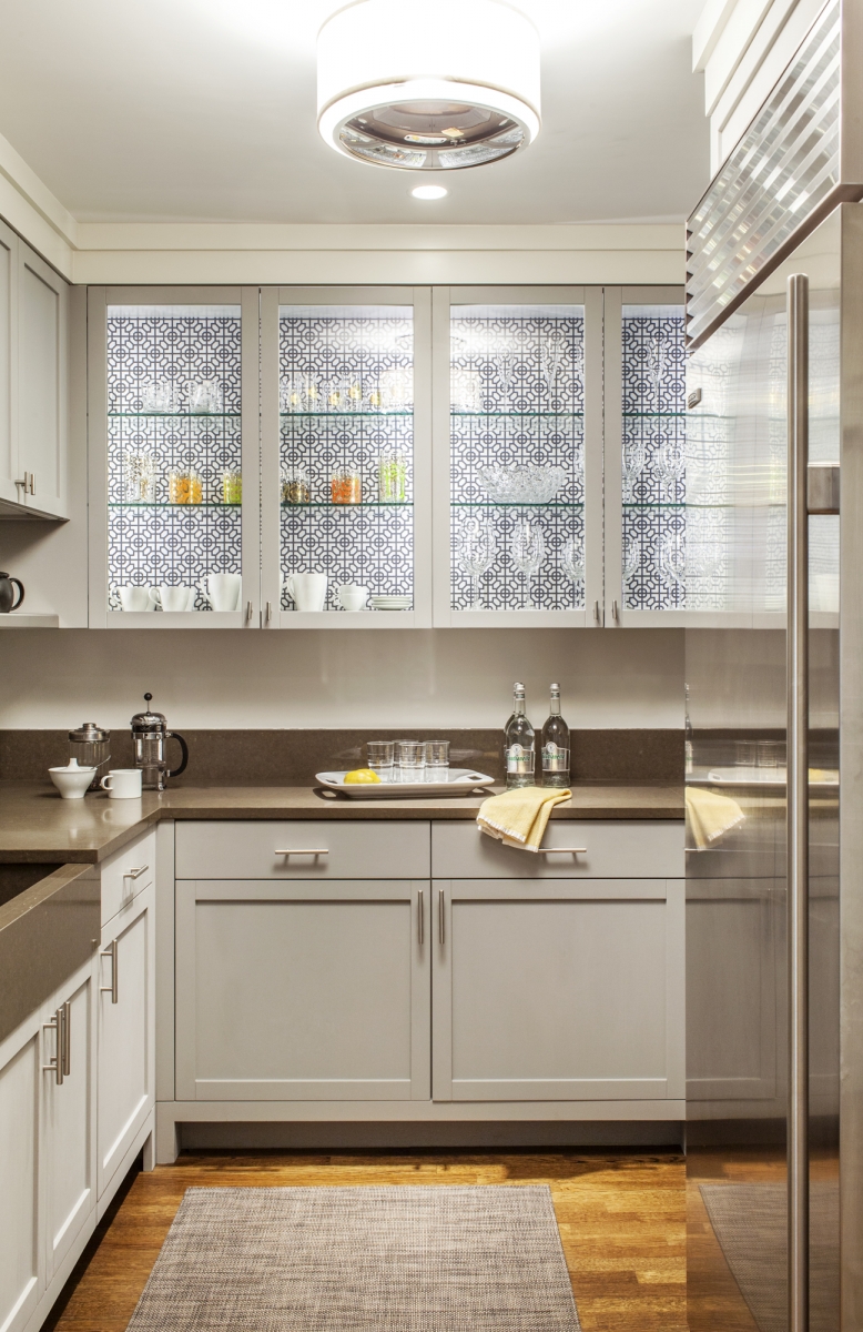 Butler's pantry, painted grey with patterned wallpaper, and glass cabinets